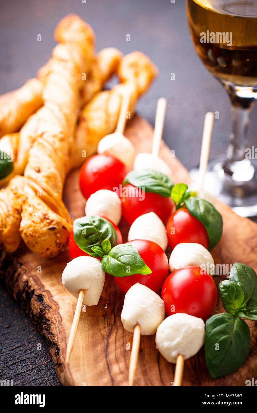 Traditional Italian antipasto caprese skewers and grissini bread Stock