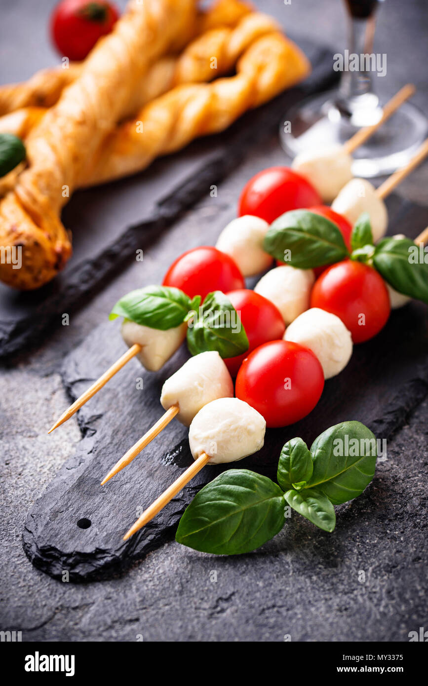 Traditional Italian antipasto caprese skewers and grissini bread Stock