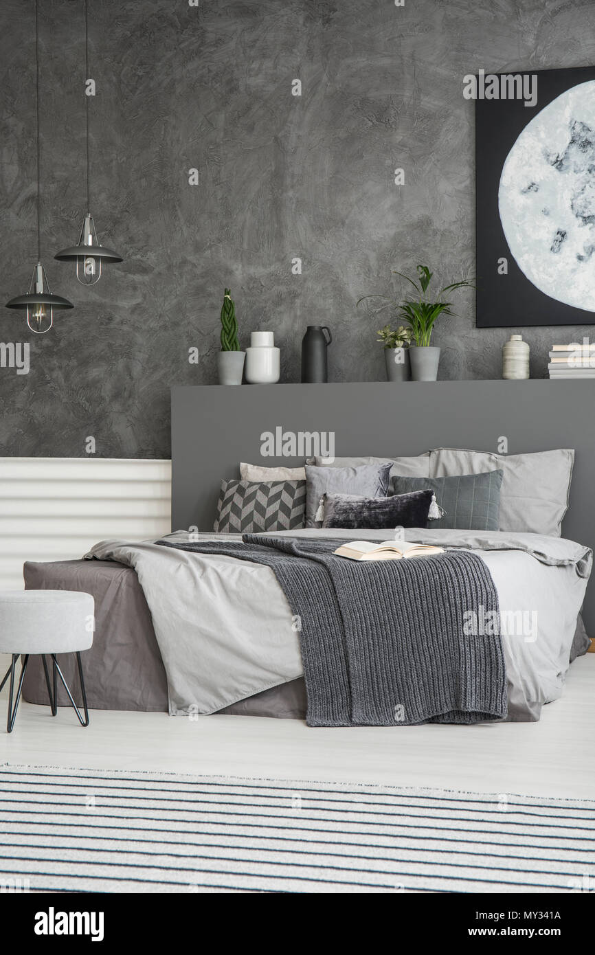 Grey sheets on bed in monochromatic dark bedroom interior with poster on  the wall. Real photo Stock Photo - Alamy, image size:866x1390