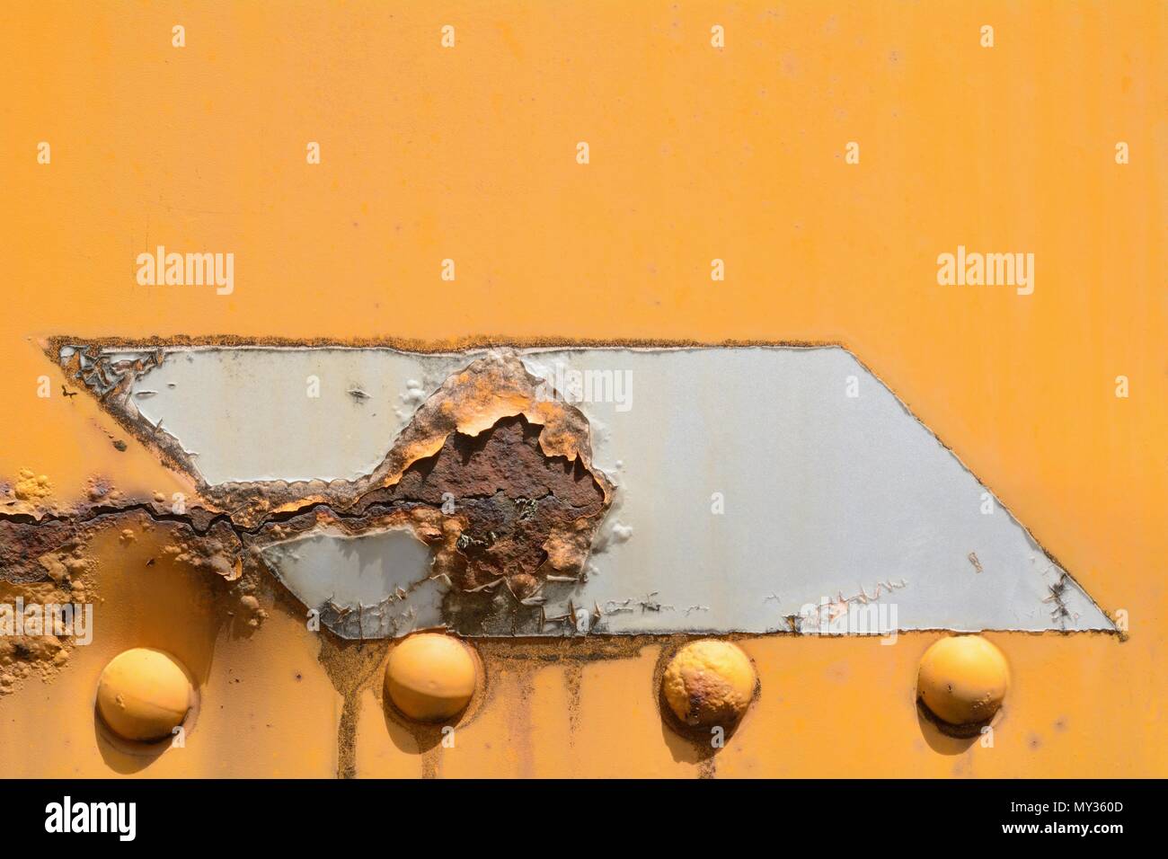 Close up of rusted parallelogram on yellow wall of caboose Stock Photo