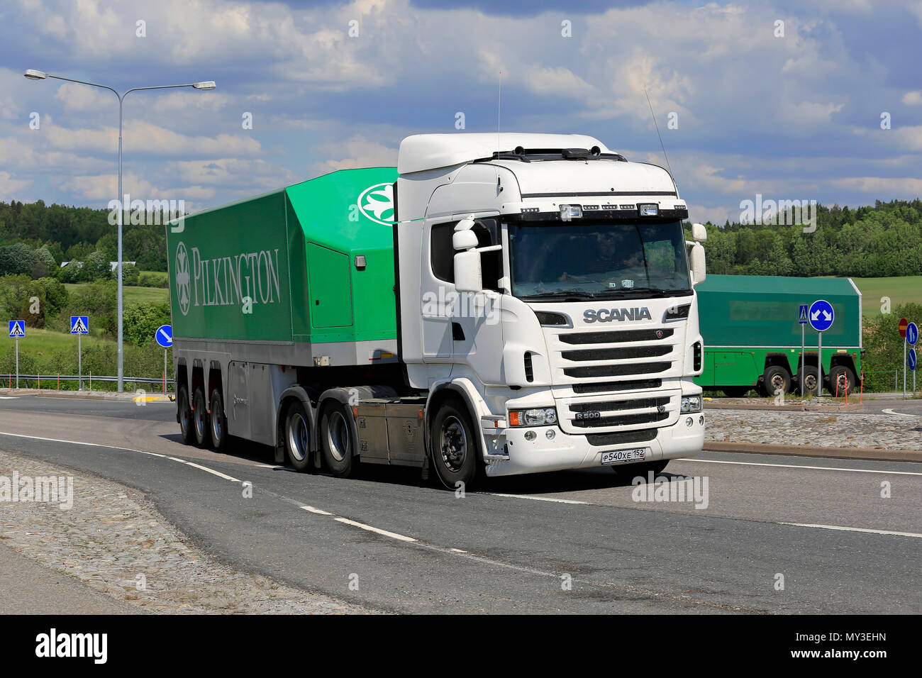 Glass transporters, White Scania R560 and Pilkington Glass Trailer in front, on intersection on a day of summer in Salo, Finland - June 2, 2018. Stock Photo
