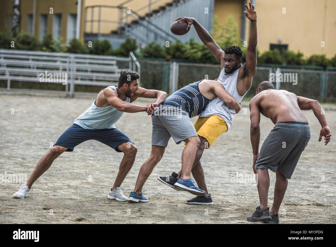 group of young multicultural men playing football on court Stock Photo ...