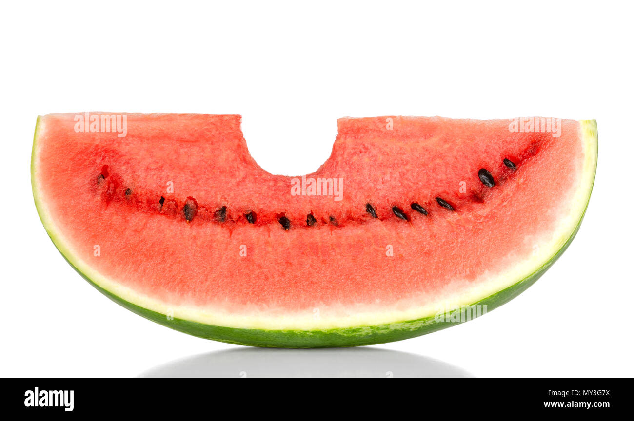 Bitten into a sweet watermelon slice, front view, over white. Large ripe fruit of Citrullus lanatus with green striped skin, red pulp and black seeds. Stock Photo