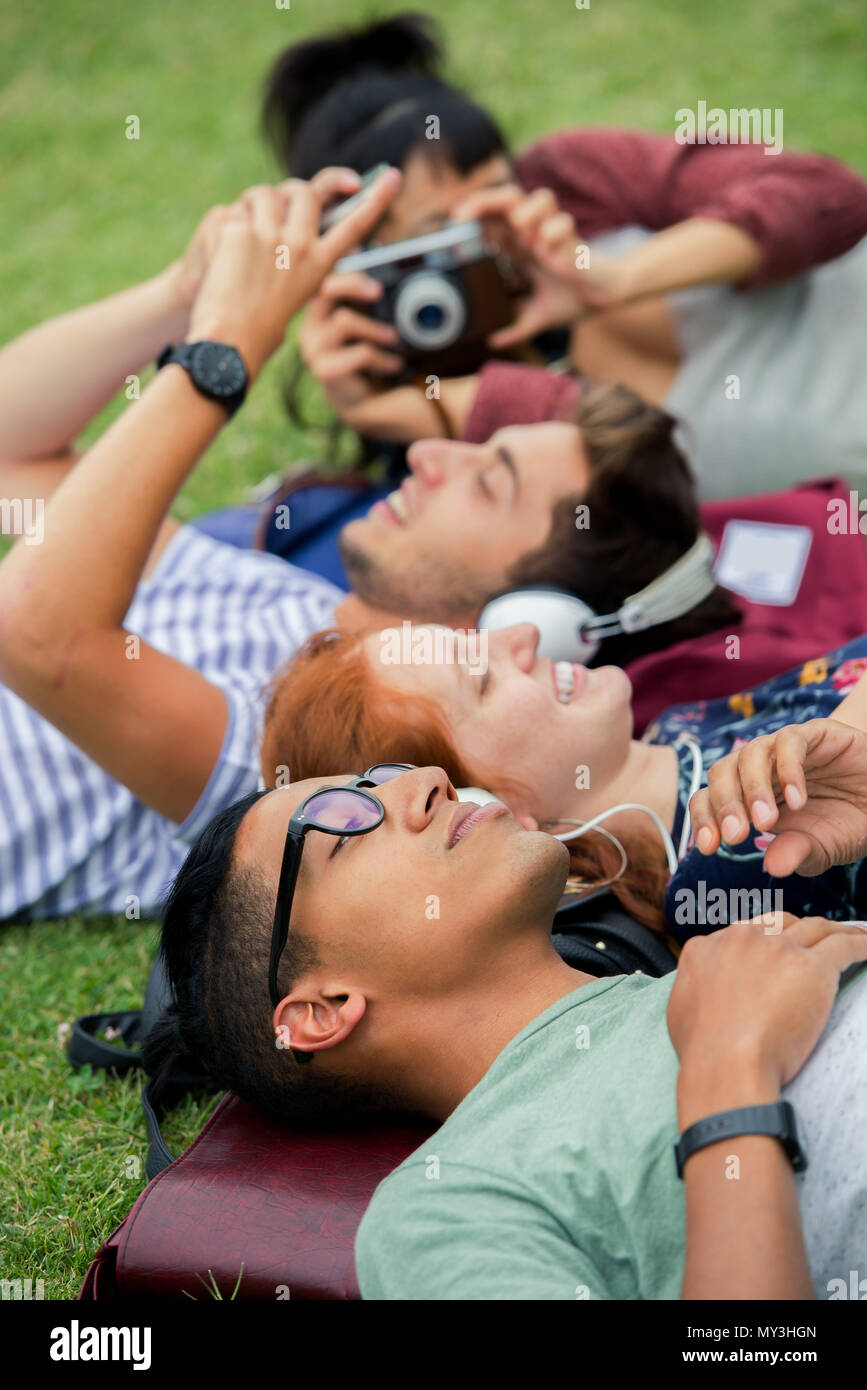 College friends relaxing together on grass Stock Photo