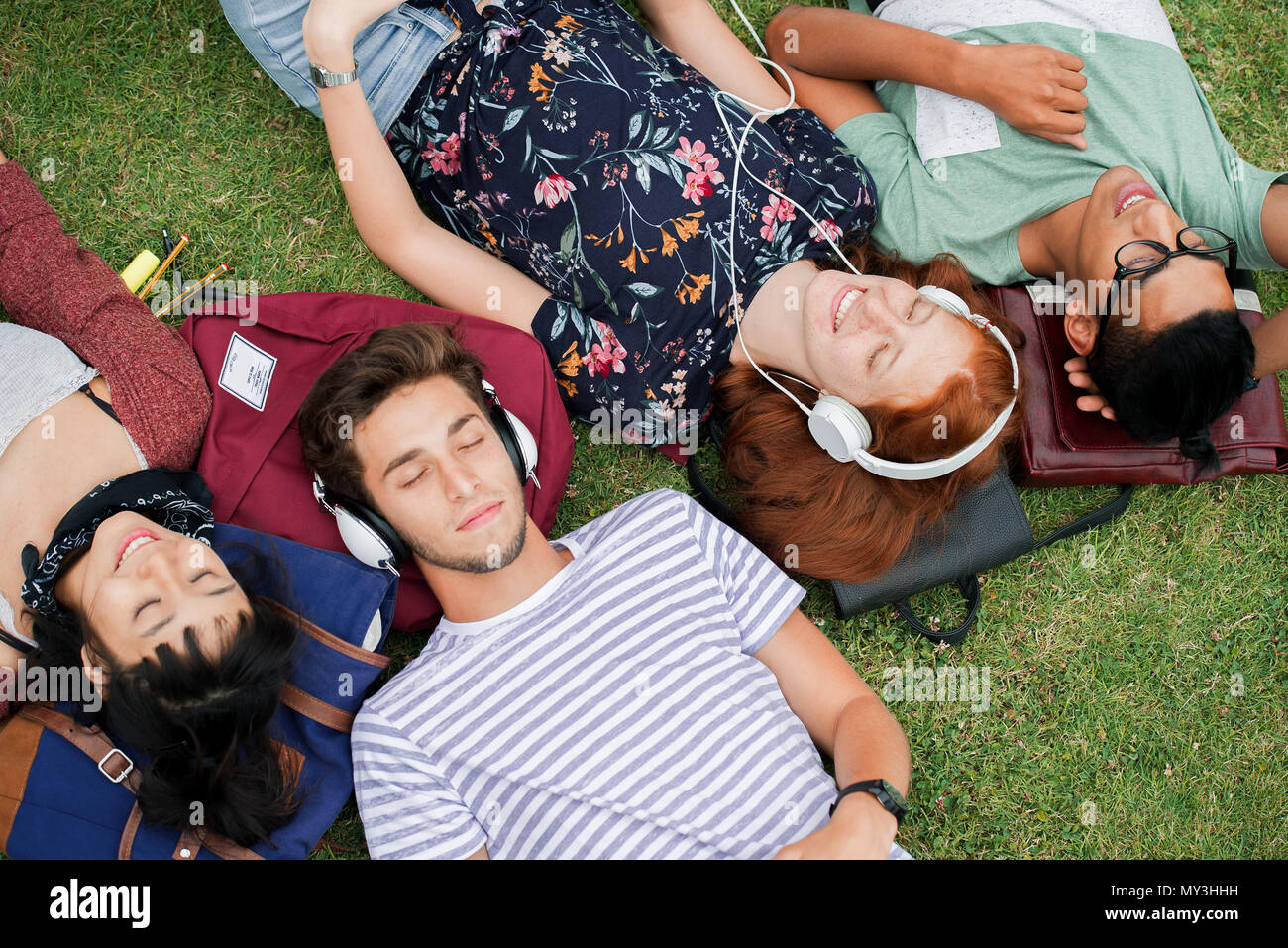 Friends relaxing together on lawn Stock Photo