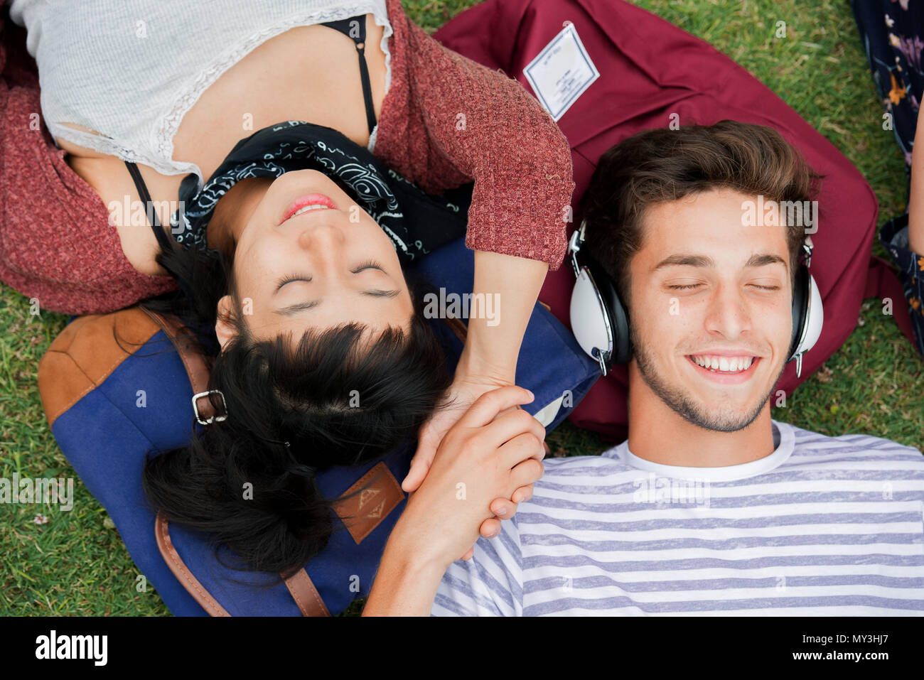 Young couple relaxing on grass together, overhead view Stock Photo - Alamy