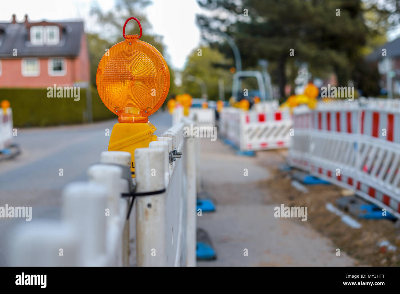 red and white barricades with warning lights at a street in the residential zone, depth of field Stock Photo