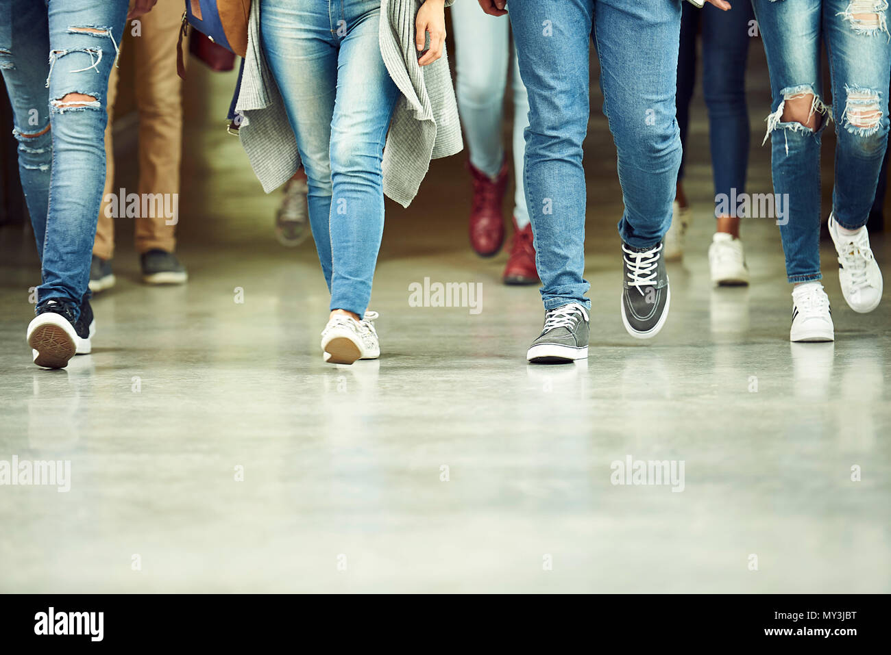 High school students walking in corridor, low section Stock Photo