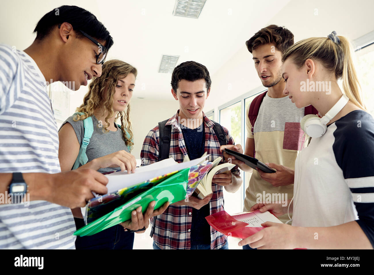 Group of students studying together in school corridor Stock Photo