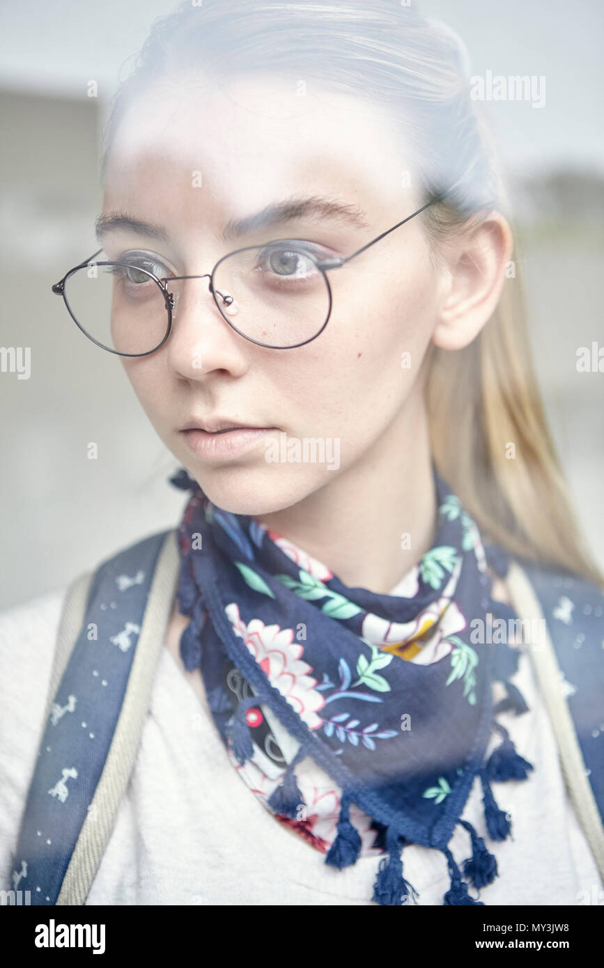 Young woman looking through window, portrait Stock Photo