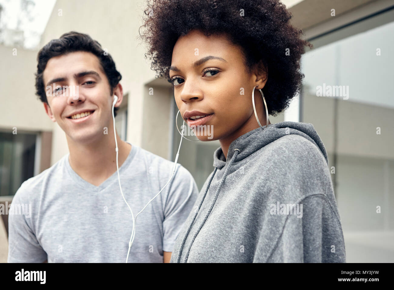 Friends listening to music together with earphones, portrait Stock Photo