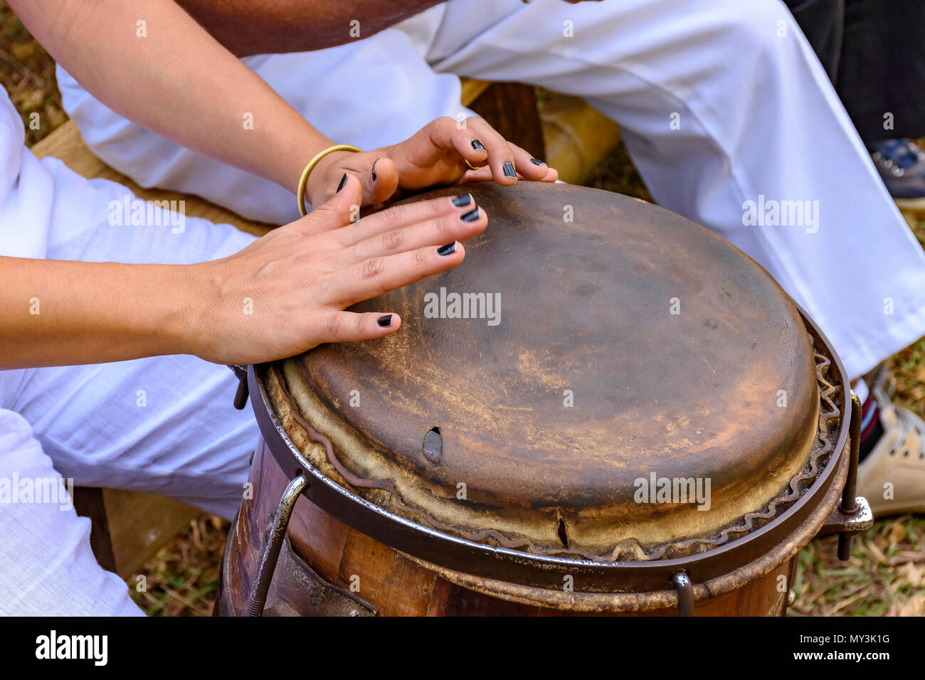 Young woman percussionist hands playing a drum called atabaque during brazilian folk music performance Stock Photo