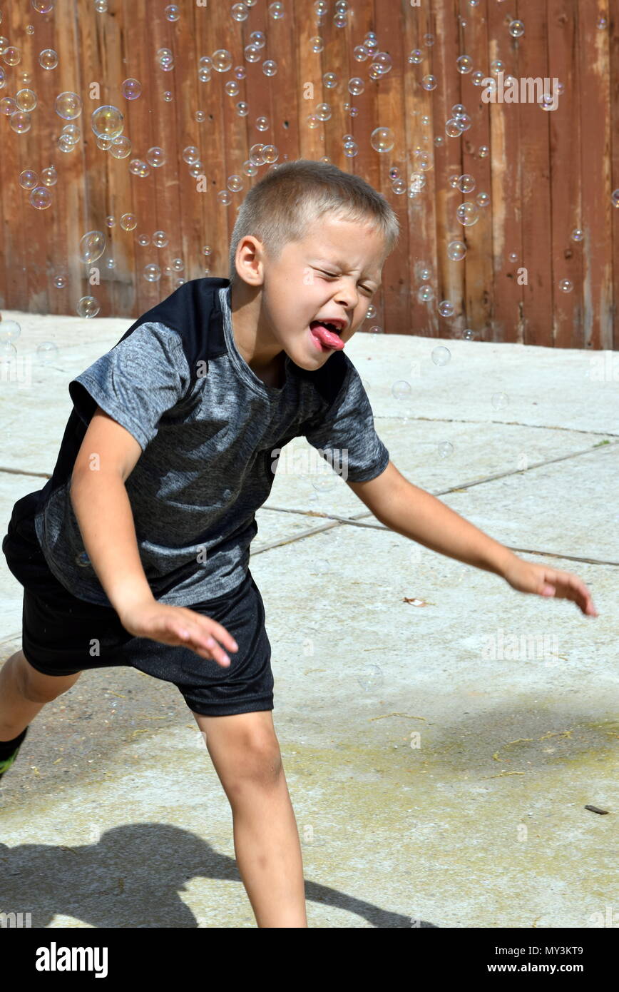 boy playing in bubbles Stock Photo