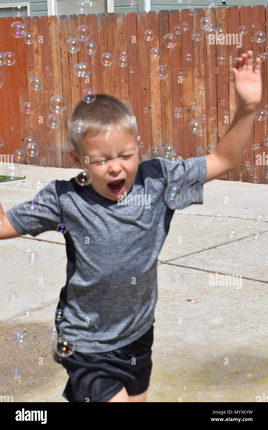 boy playing in bubbles Stock Photo