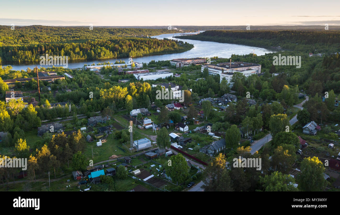 Bird's eye view of houses in urban-type settlement Nikolskiy, Svir river and summer green forests of Leningrad region, Russia. Stock Photo