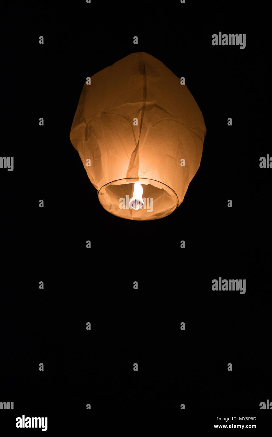 A flying Chinese lantern in the night sky Stock Photo