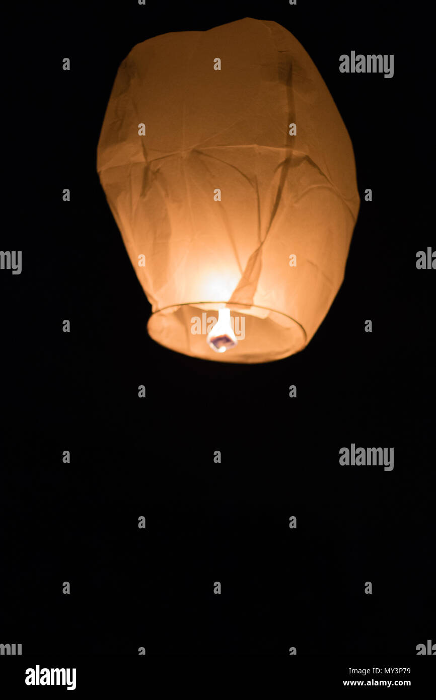 A flying Chinese lantern in the night sky Stock Photo
