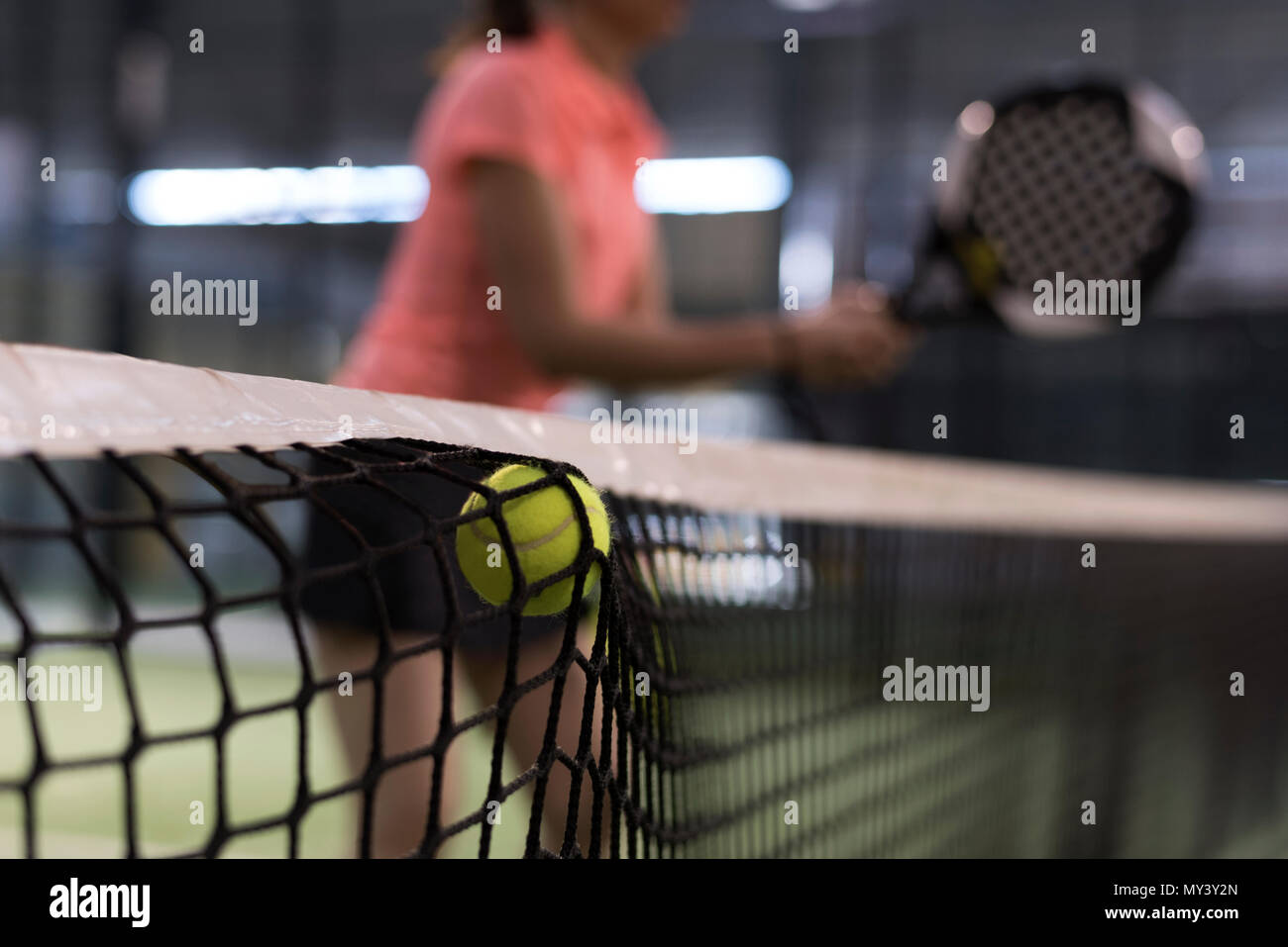 paddle tennis shot in macth, woman in background Stock Photo