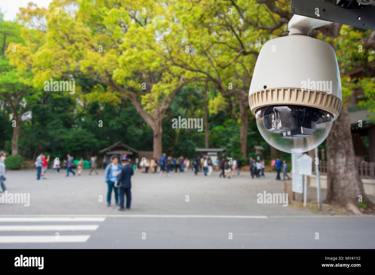 CCTV Camera or surveillance operating in outdoor park with people in