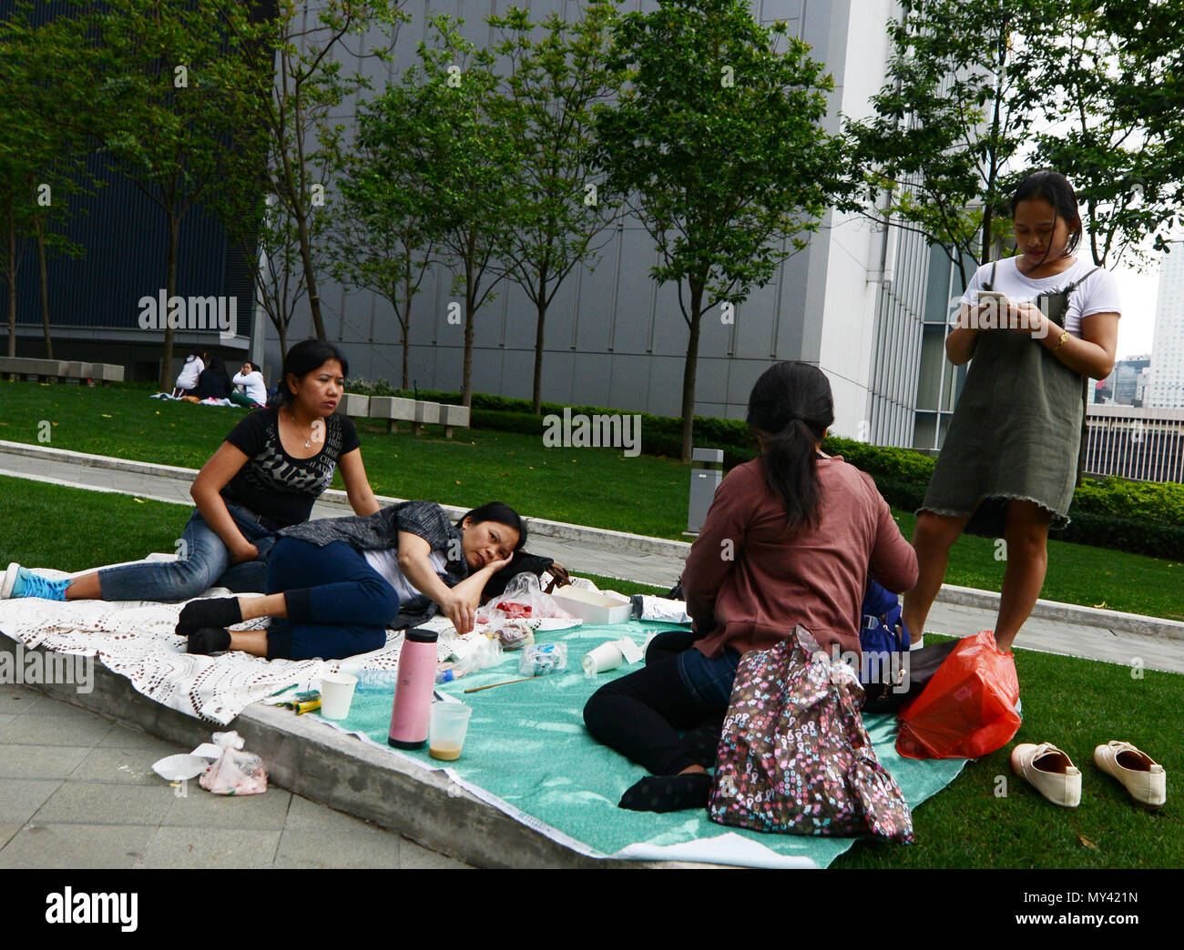 Filipina domestic helpers enjoying their Sunday day off in Tamar park in Hong Kong. Stock Photo