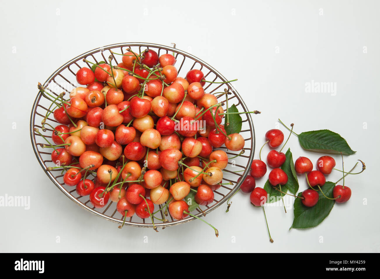 cherries in a metal basket view from above Stock Photo