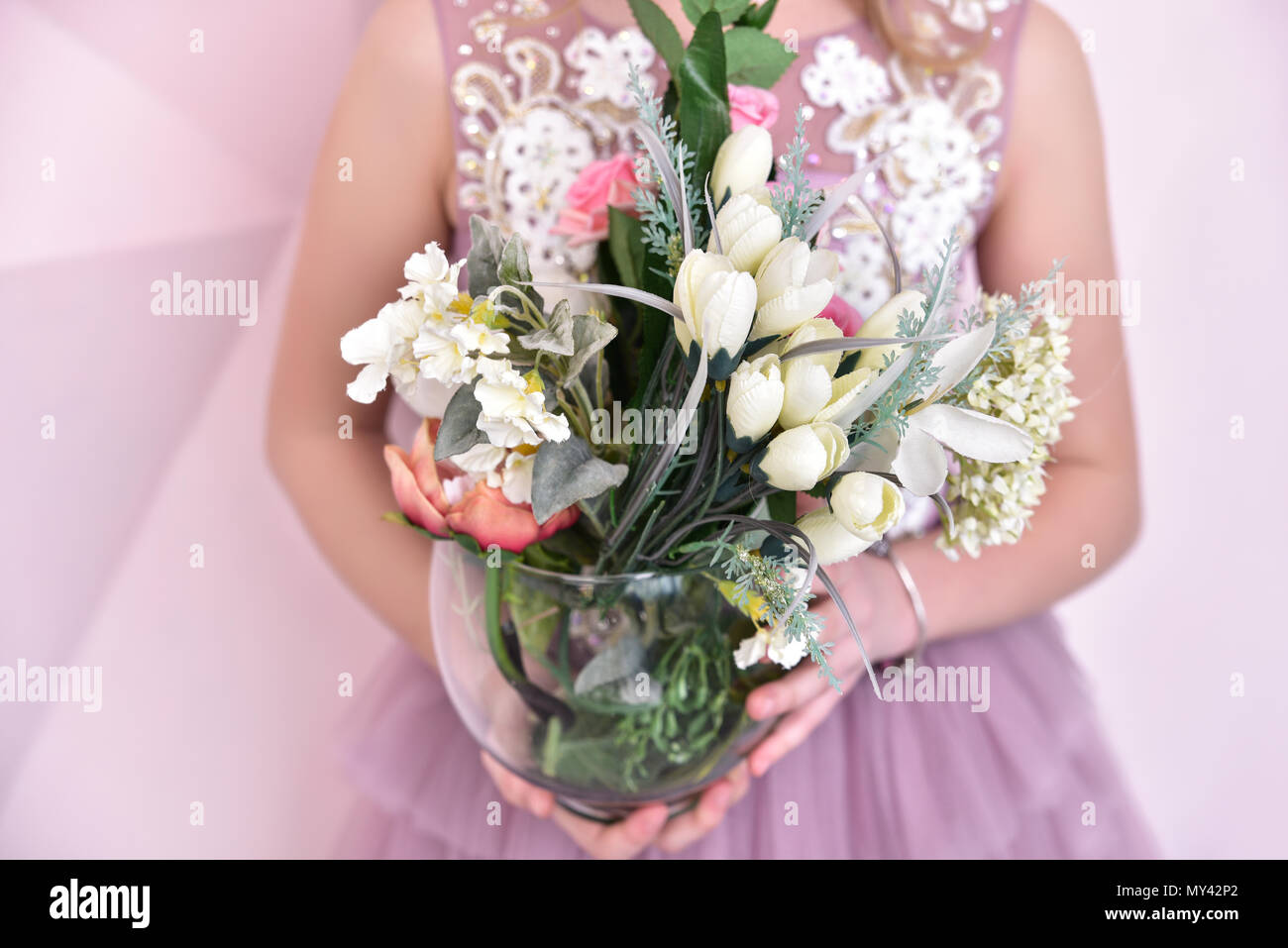 little girl with artificial flowers, close-up view Stock Photo