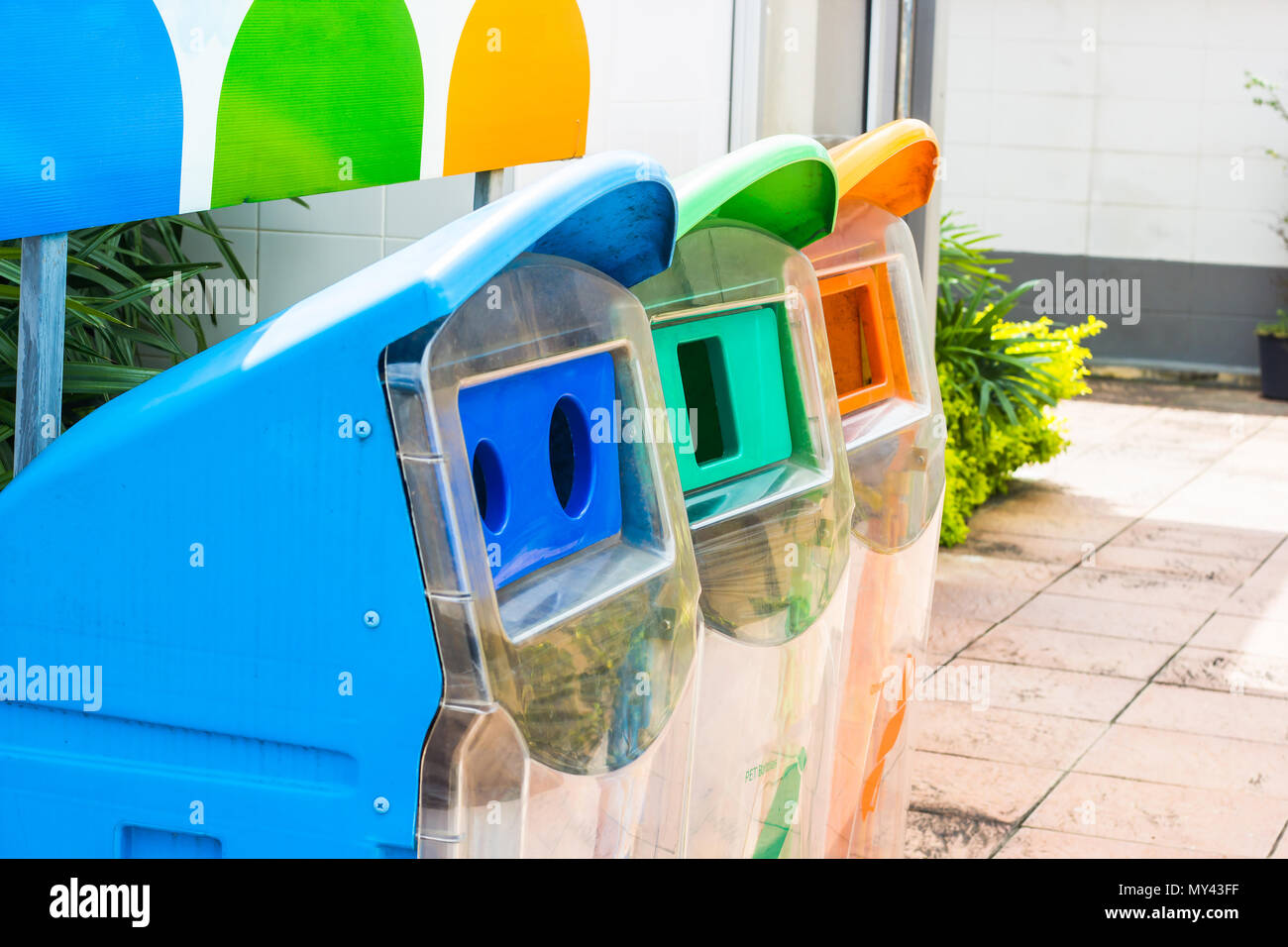 Close up yellow, green, blue recycle bins with recycle symbol in the