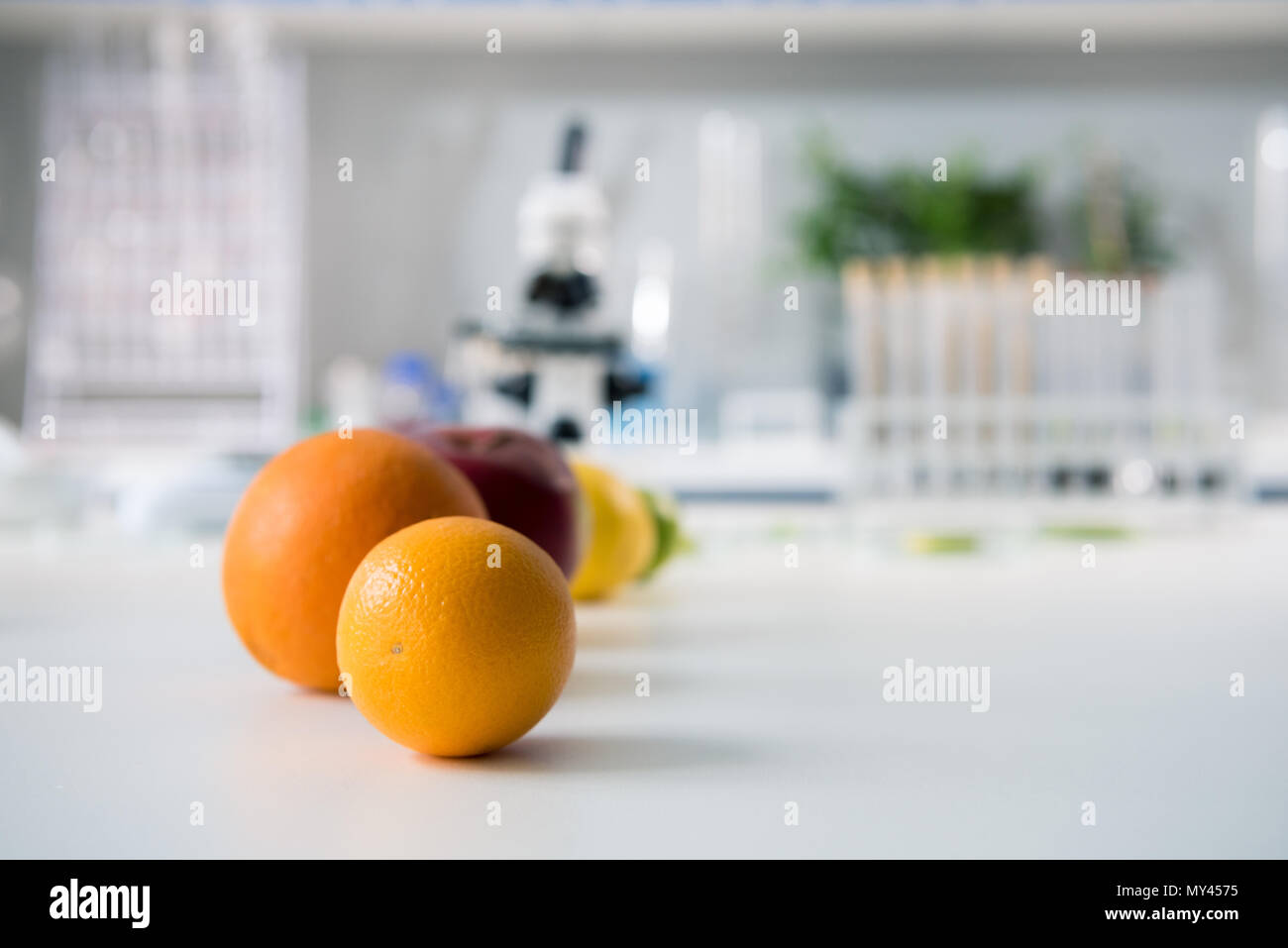 Scientific tools and fruits at workplace in modern biological laboratory Stock Photo