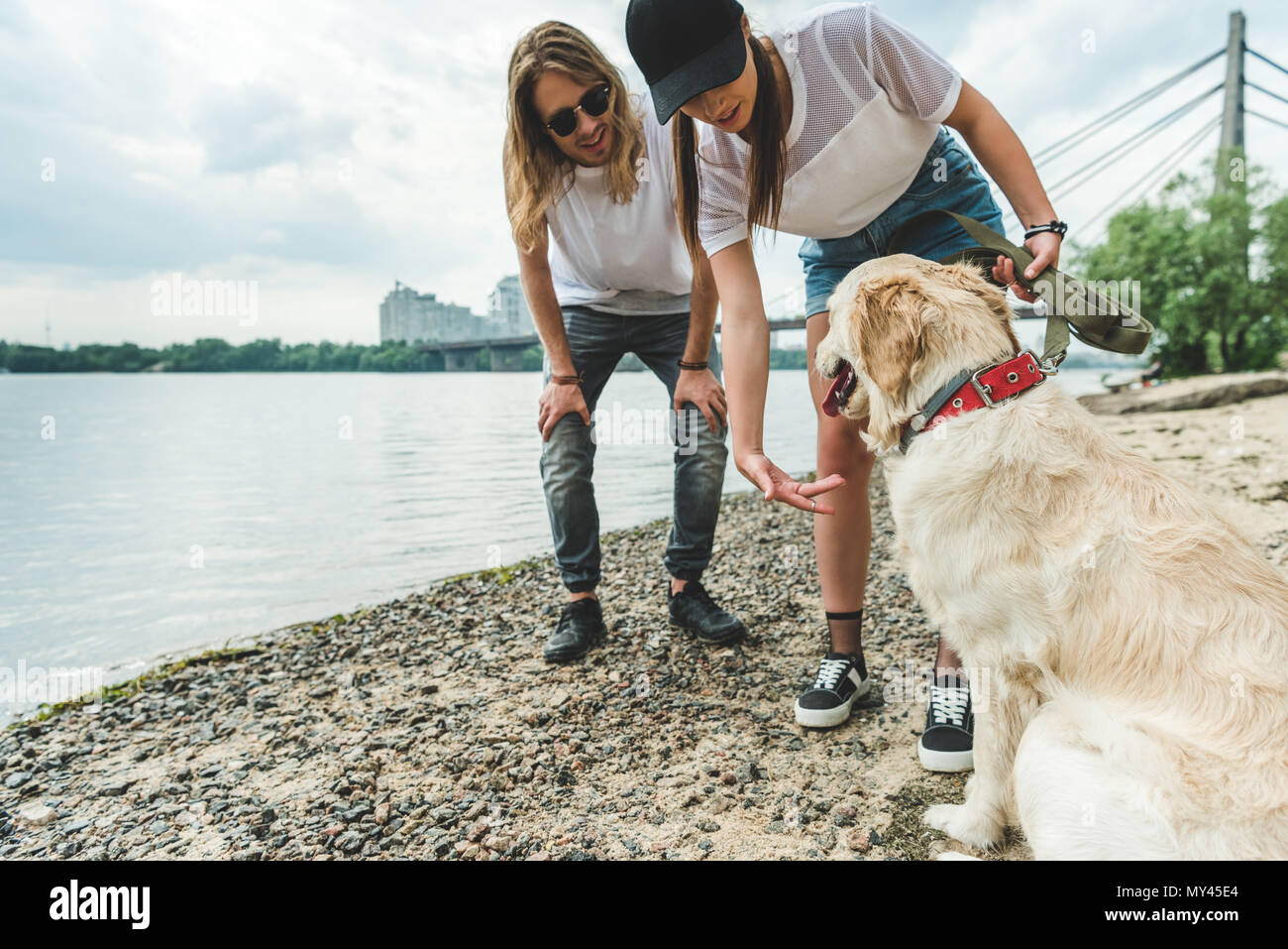 beautiful young couple with dog on beach Stock Photo - Alamy