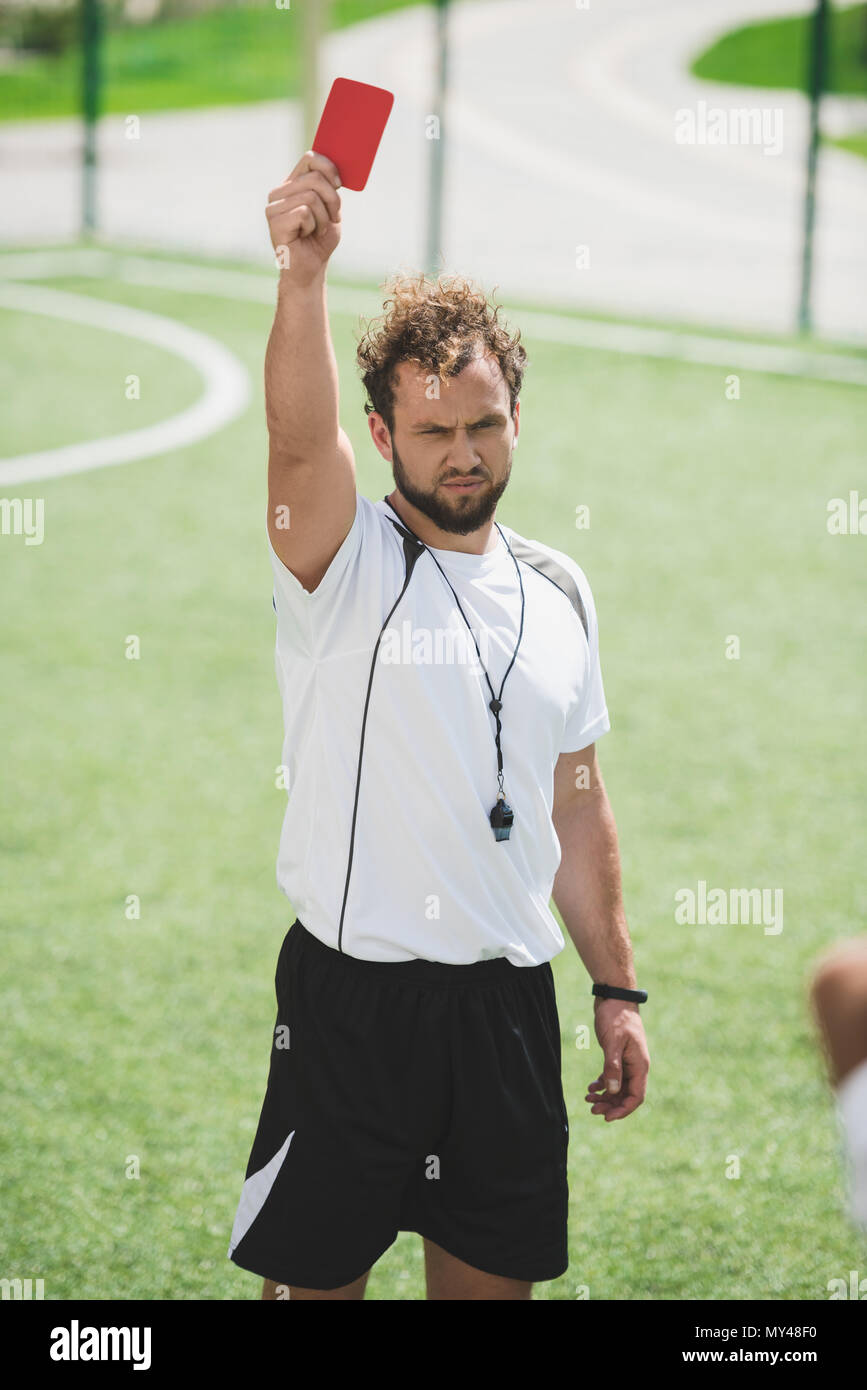 soccer referee showing red card during soccer match on pitch Stock Photo