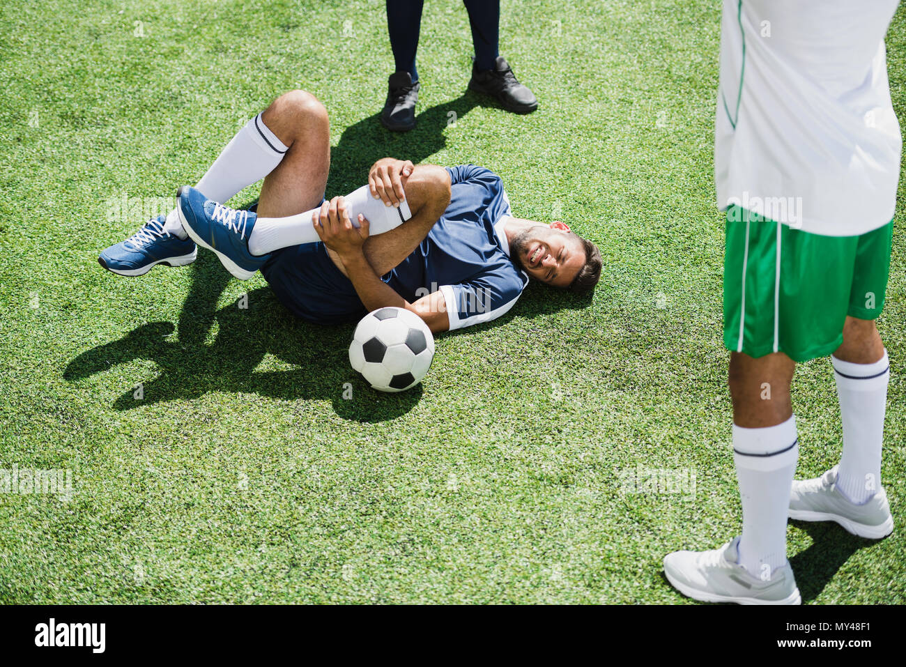 injured soccer player lying on football field during match Stock Photo -  Alamy