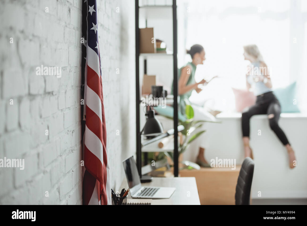 closeup shot of united states of america flag and two women on blurred background Stock Photo
