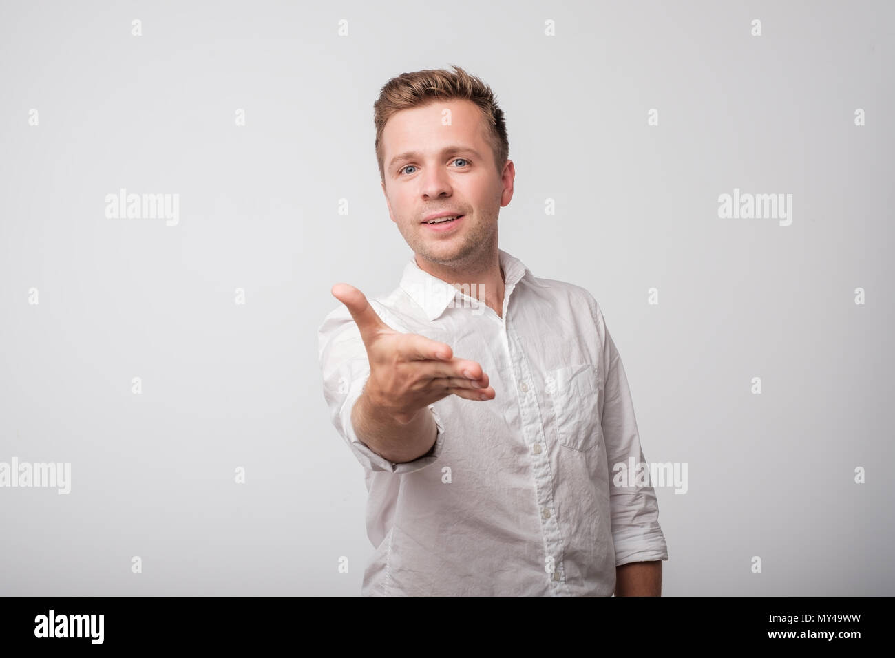 Caucasian man in white shirt shaking hands isolated on white background. Stock Photo