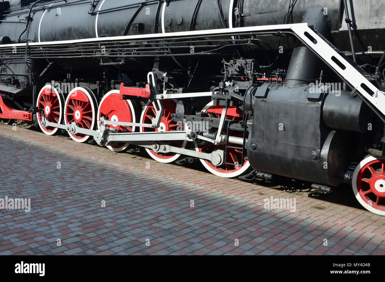 Wheels of the old black steam locomotive of Soviet times. The side of ...