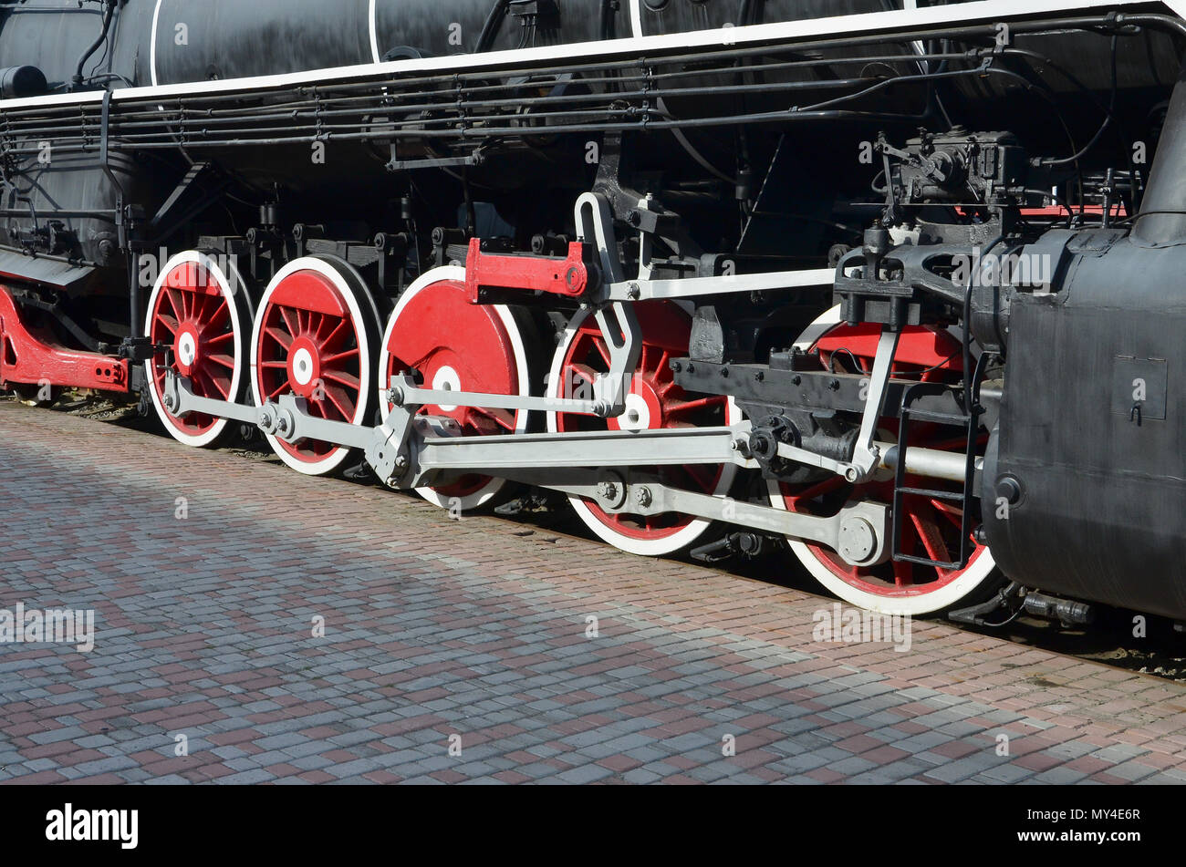 Wheels of the old black steam locomotive of Soviet times. The side of ...