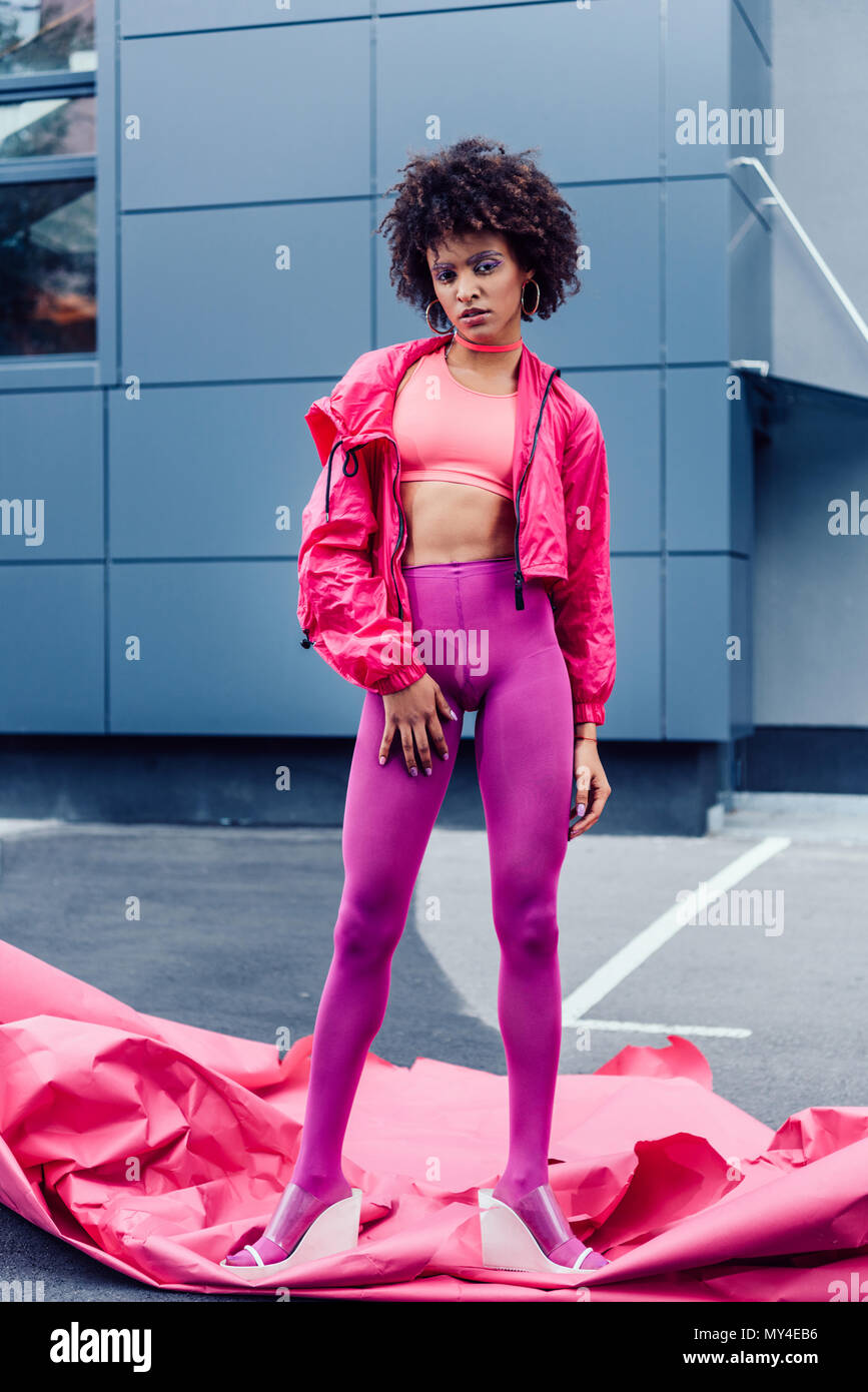 fashionable african american girl posing in 80s style clothes with pink  paper Stock Photo - Alamy