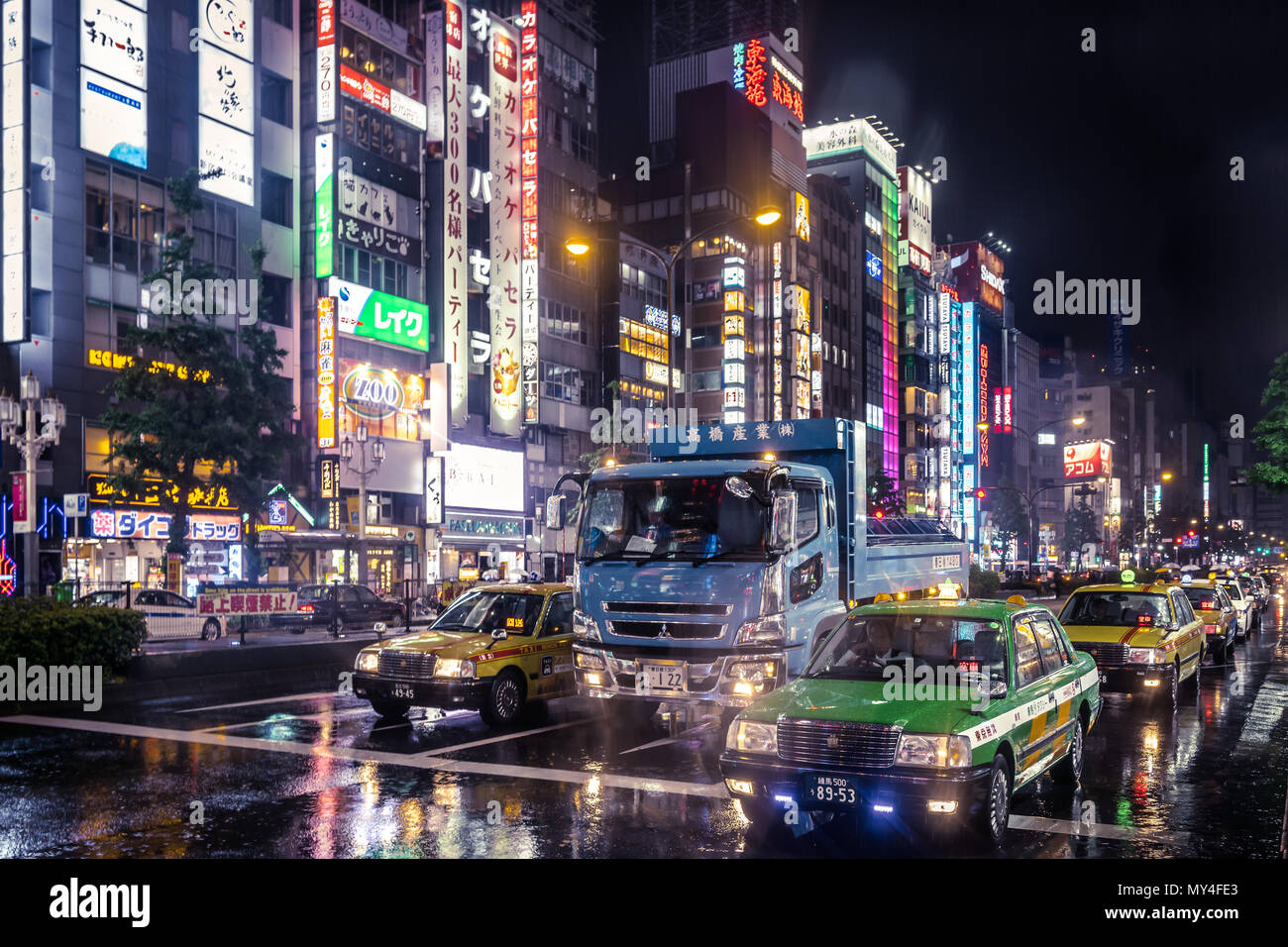 Neon lights on a busy street at night in Tokyo Stock Photo