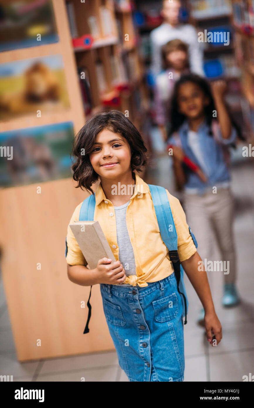 adorable little girl with book in library Stock Photo - Alamy