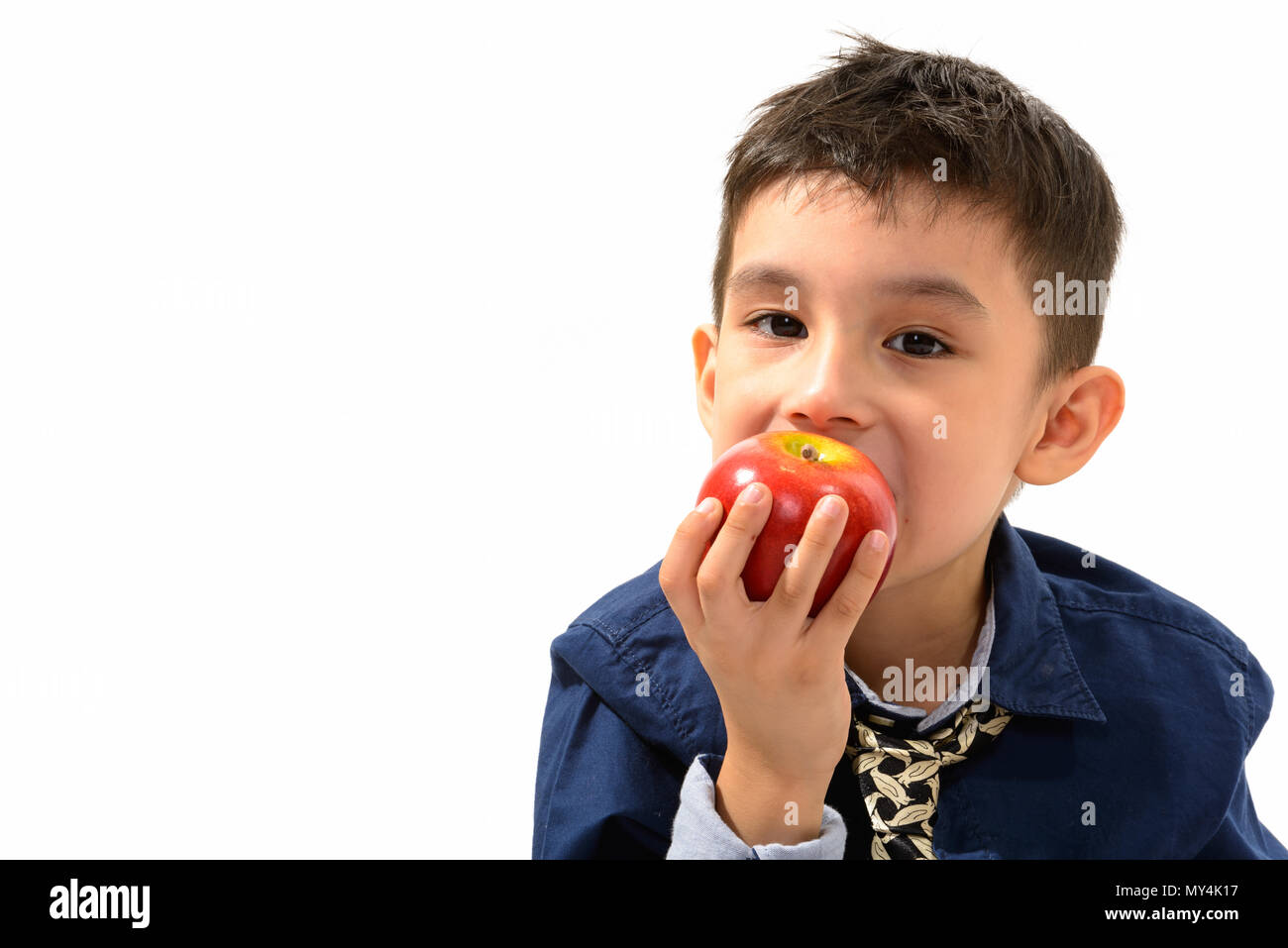 Studio shot of cute boy eating apple Stock Photo