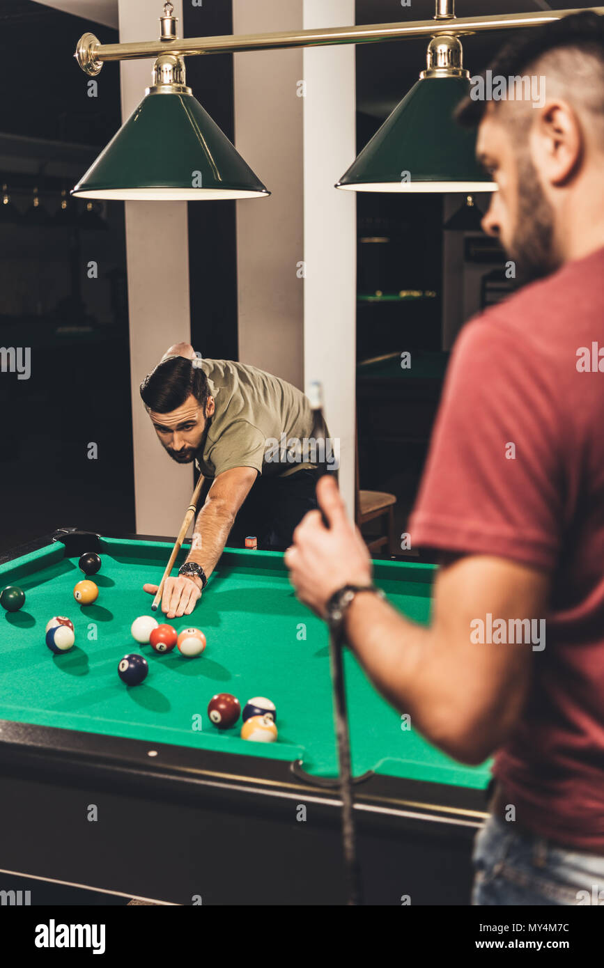 couple of young successful handsome men playing in pool at bar Stock Photo