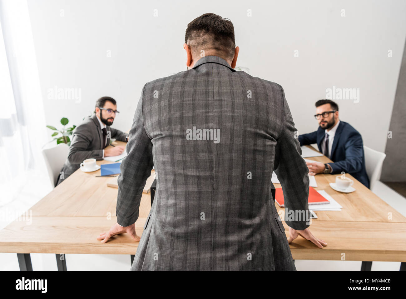 rear view of team leader standing and looking at workers Stock Photo