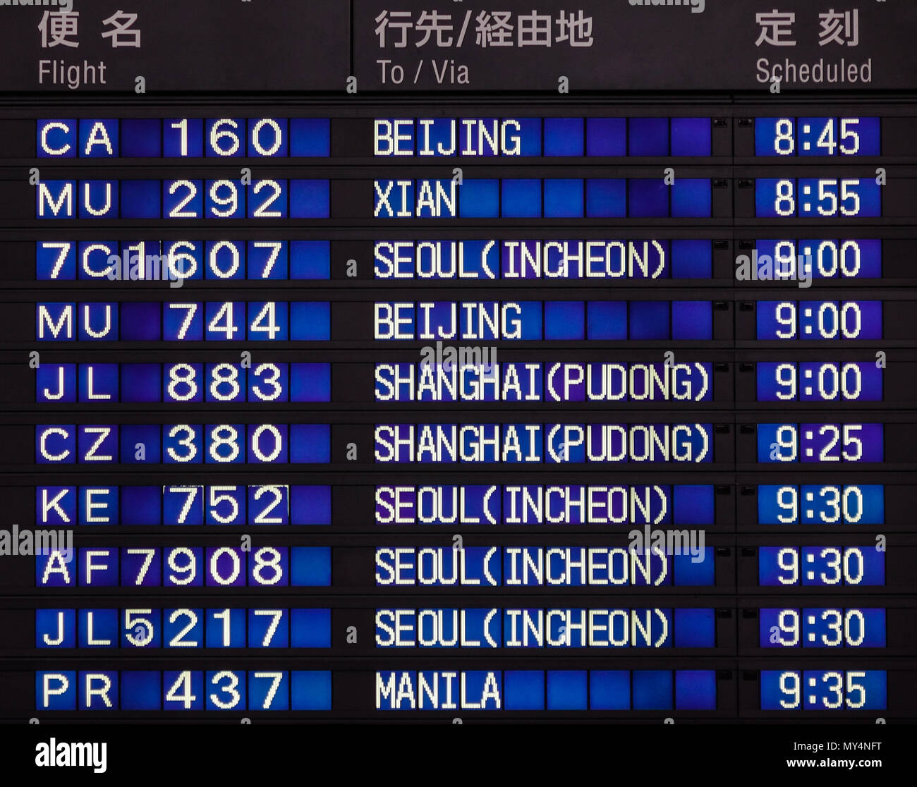 Airport board showing departures and arrivals to various cities Stock