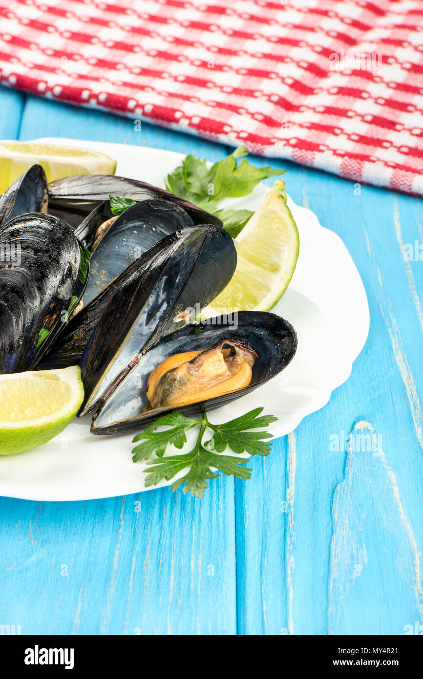 Delicious mussels in the shell on a plate and table Stock Photo Alamy