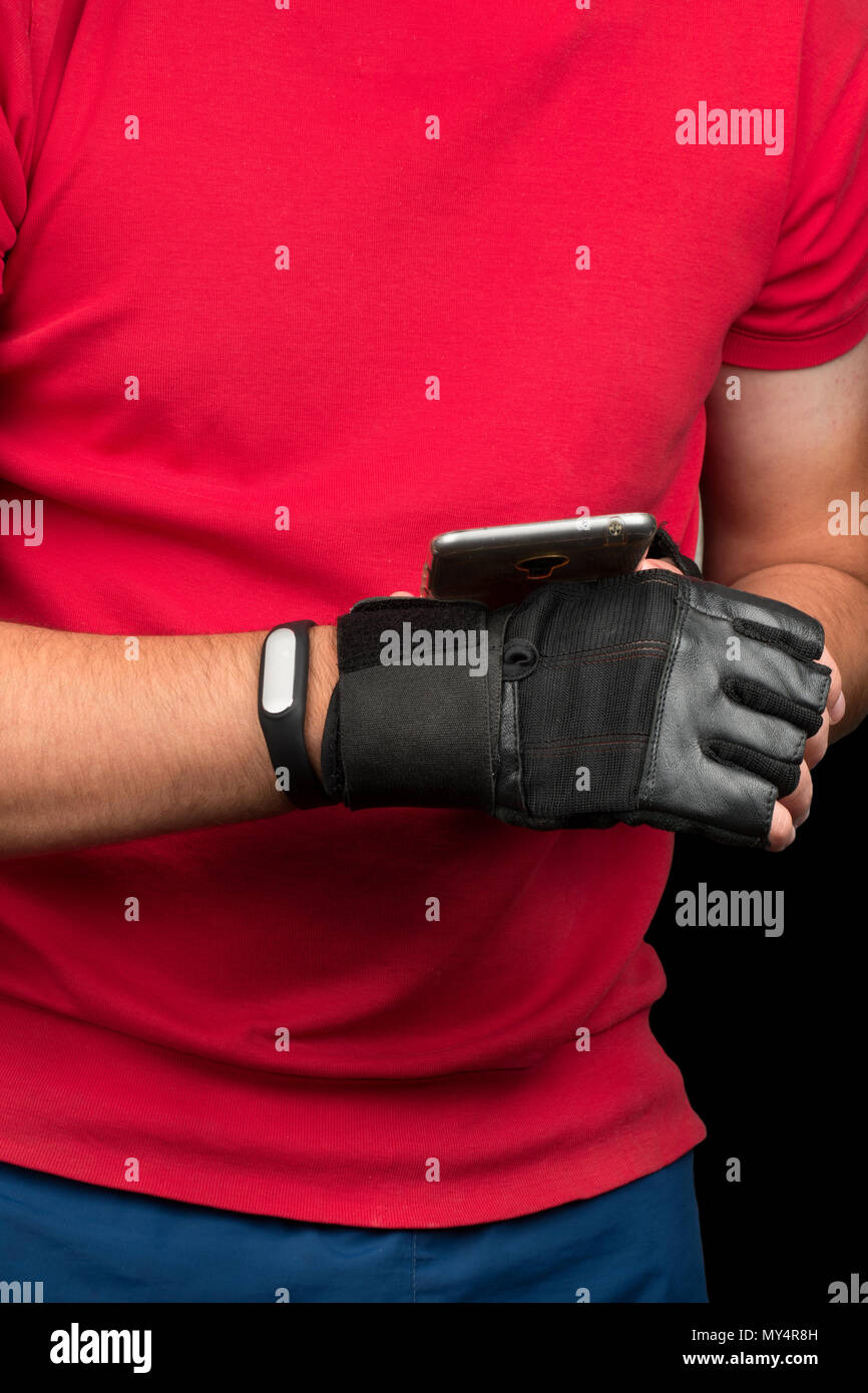Young athlete synchronizes fitness bracelet with smartphone Stock Photo