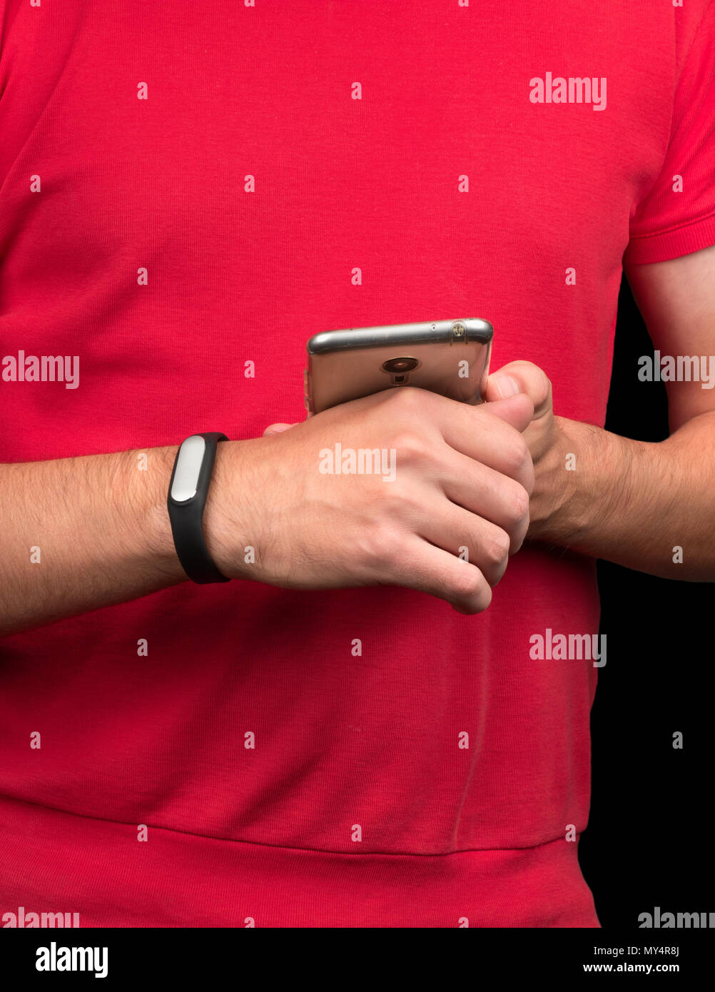 Young athlete synchronizes fitness bracelet with smartphone Stock Photo