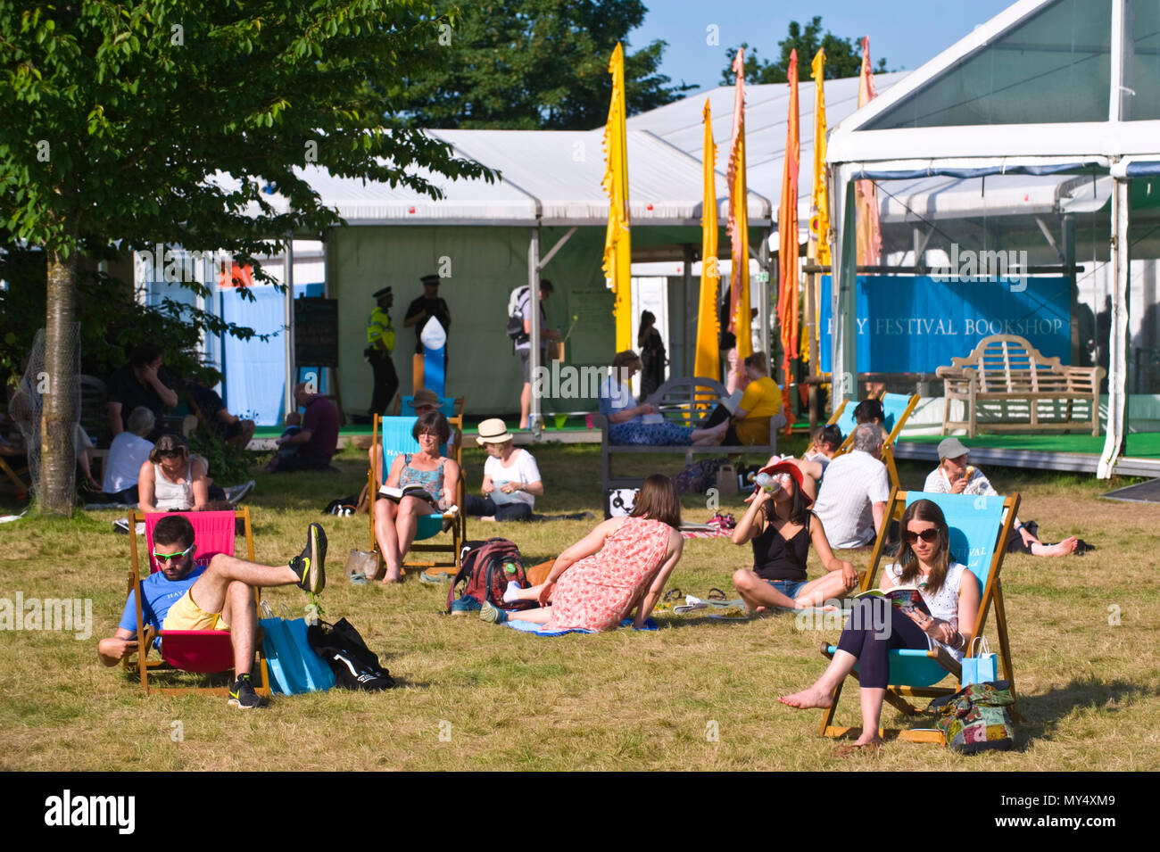 People relaxing on lawn in late afternoon summer sunshine in garden area at Hay Festival 2018 Hay-on-Wye Powys Wales UK Stock Photo