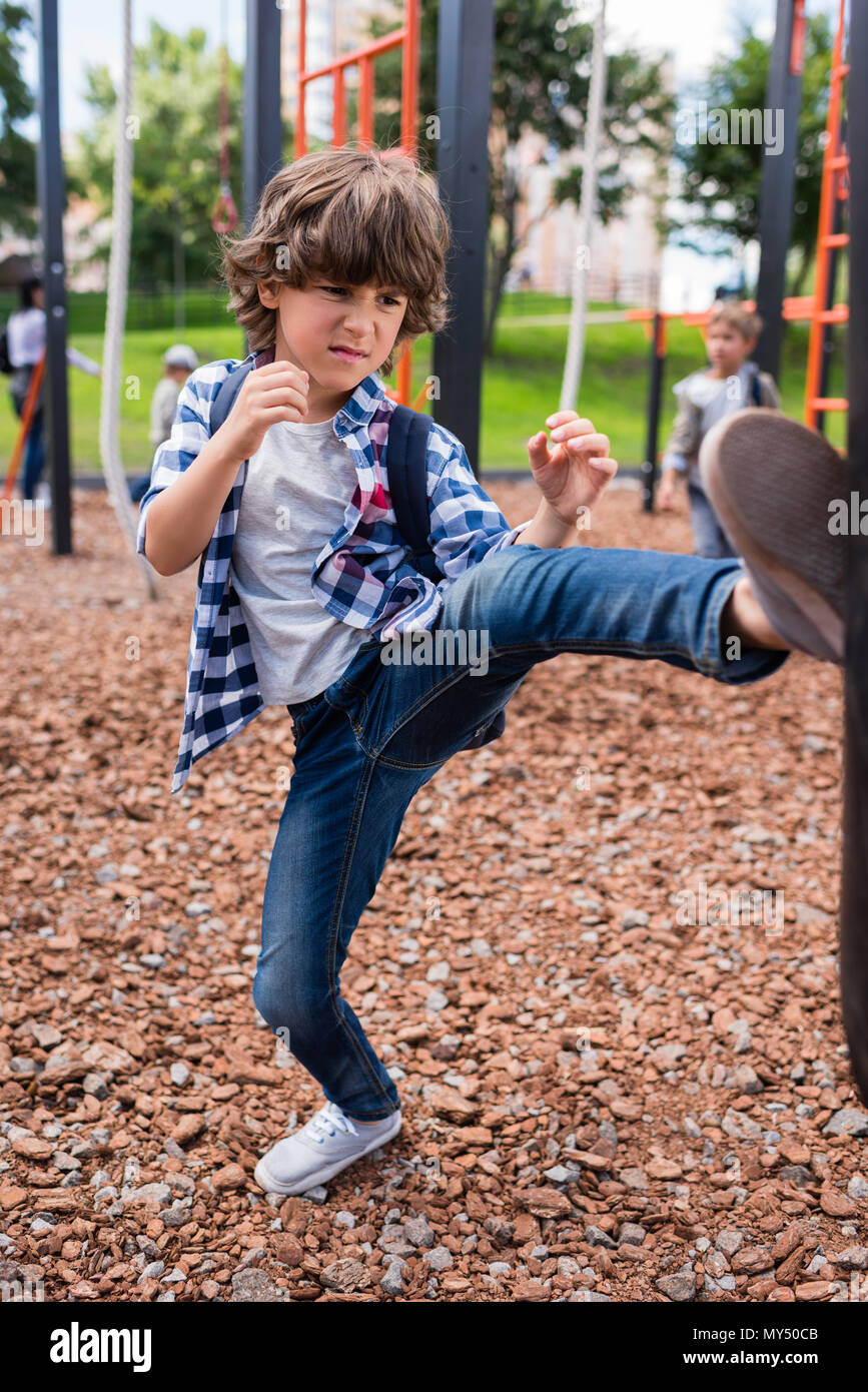 serious little boy hitting punching bag on playground Stock Photo Alamy