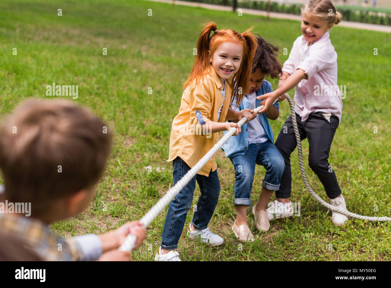 happy beautiful multiethnic kids pulling rope in park Stock Photo - Alamy