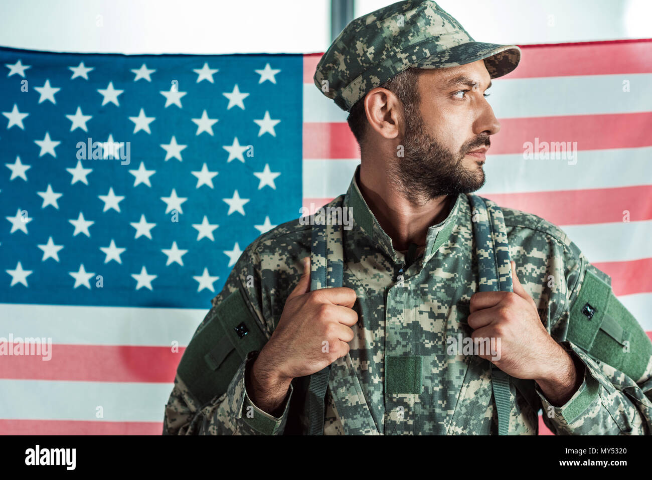 portrait of soldier in military uniform looking away against american ...
