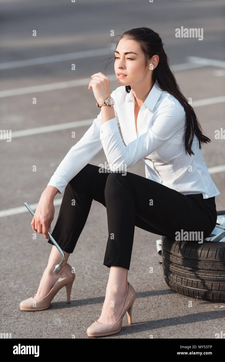 Wench on streets crossing her sexy legs while sitting